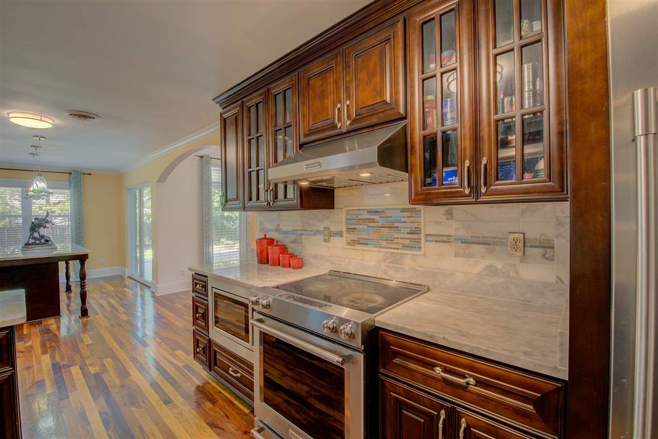 1915 Corbin Road Germantown, TN 38139 - Photo 10 of 25 Cooking will be a delight in this incredible eat-in kitchen with cabinet and counter space galore, desirable marble countertops, marble backsplash, walnut hardwood floors, gorgeous cabinetry, pantry, full complement of stainless steel appliances.