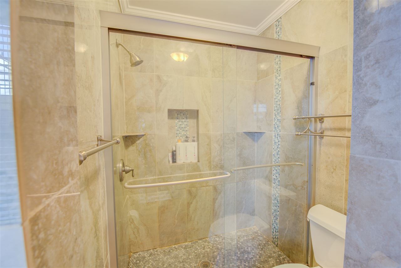 1915 Corbin Road Germantown, TN 38139 - Photo 15 of 25 The completely renovated spa-inspired luxury master bathroom boasts a marble vanity with magnificent cabinetry, durable tile floor, European style track light fixture, and a divine walk-in shower with a complete tile surround.
