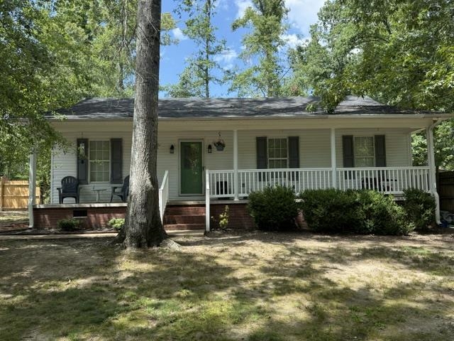 395 Austin Street Savannah, TN 38372 - Photo 32 of 32 White siding exterior with a full-width covered front porch featuring white railings and dark shutters