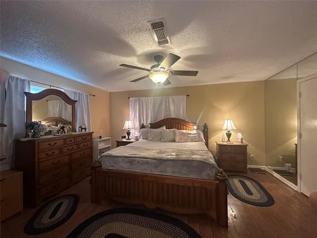 a bedroom with a bed and a mirror on the dresser