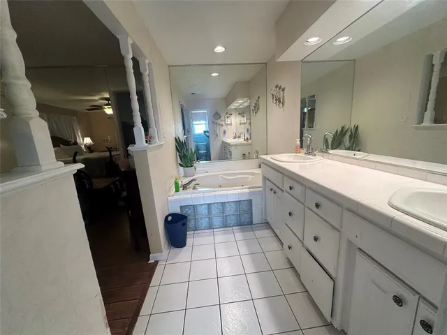 a bathroom with a double vanity sink a toilet a mirror and vanity
