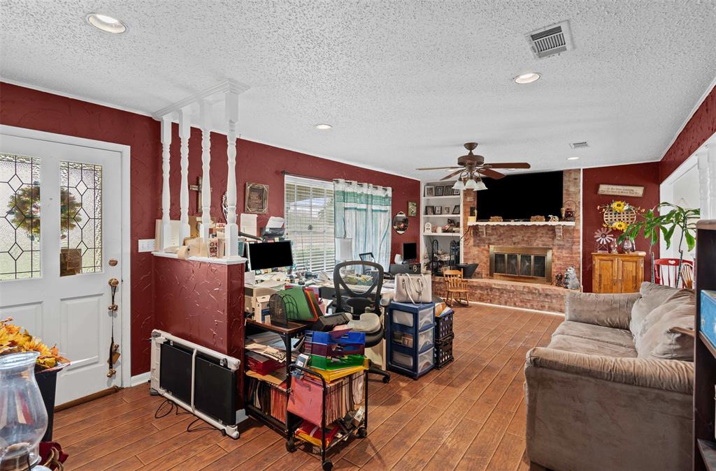 245 County Road 3696 Springtown, TX 76082 - Photo 7 of 29 a living room with furniture a fireplace and a flat screen tv