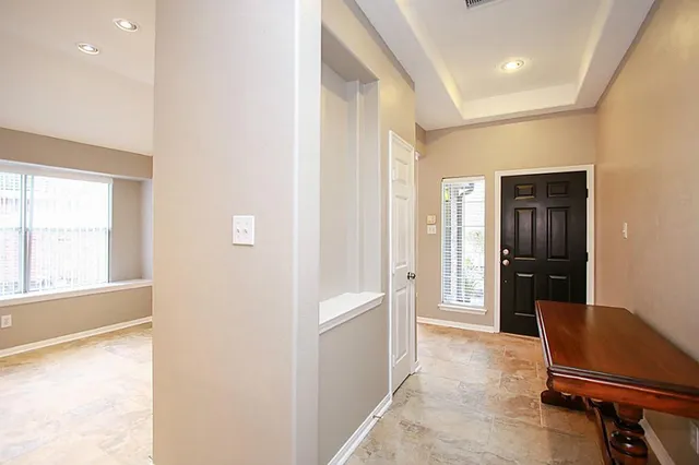 a view of a hallway with furniture and a window
