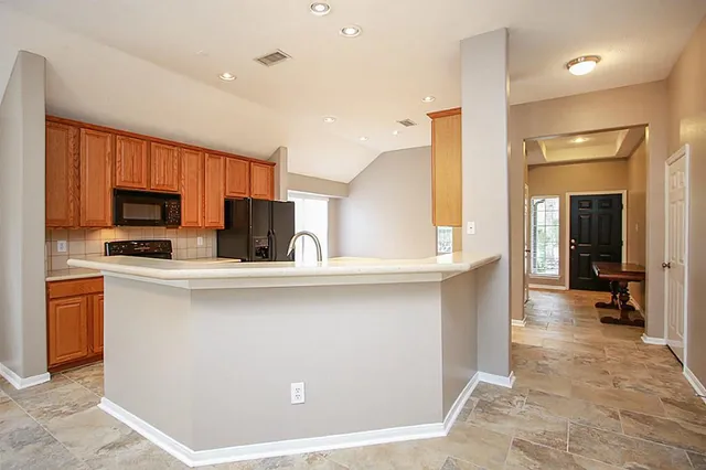 a kitchen with stainless steel appliances a refrigerator a sink a stove top oven and cabinets