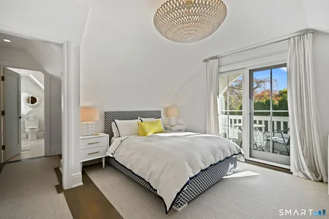 a bedroom with a bed mirror and a window