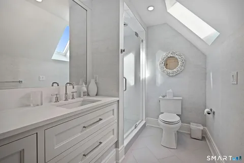 a spacious bathroom with a toilet a sink and mirror