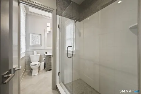 a bathroom with a granite countertop shower and a toilet
