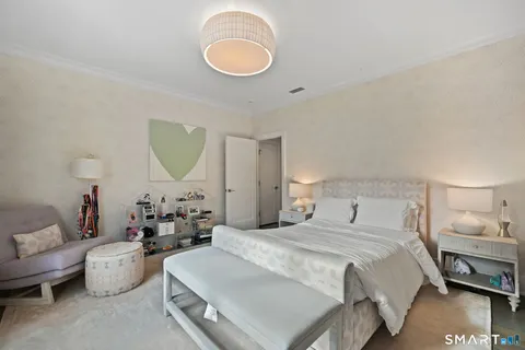 a bedroom with bed a couch and a large mirror