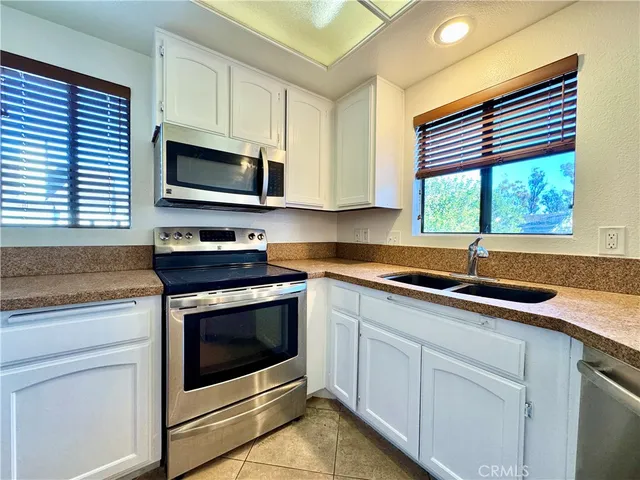 a kitchen with stainless steel appliances granite countertop a sink a stove and microwave