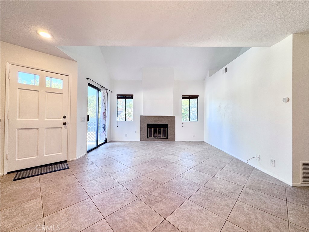 109 Fallingstar, Unit 61 Irvine, CA 92614 - Photo 9 of 34 an empty room with fireplace and windows