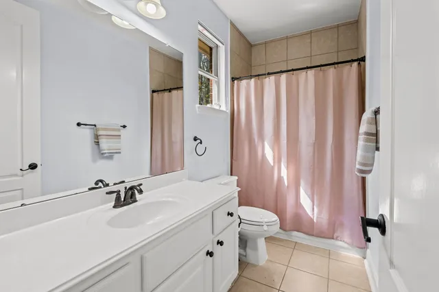a bathroom with a sink a toilet and shower curtain