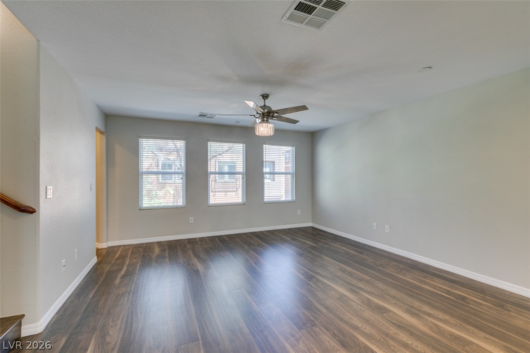 4650 Ranch House Road, Unit 46 North Las Vegas, NV 89031 - Photo 13 of 38 Rich wood-inspired floors and a trio of tall windows define this versatile living space.