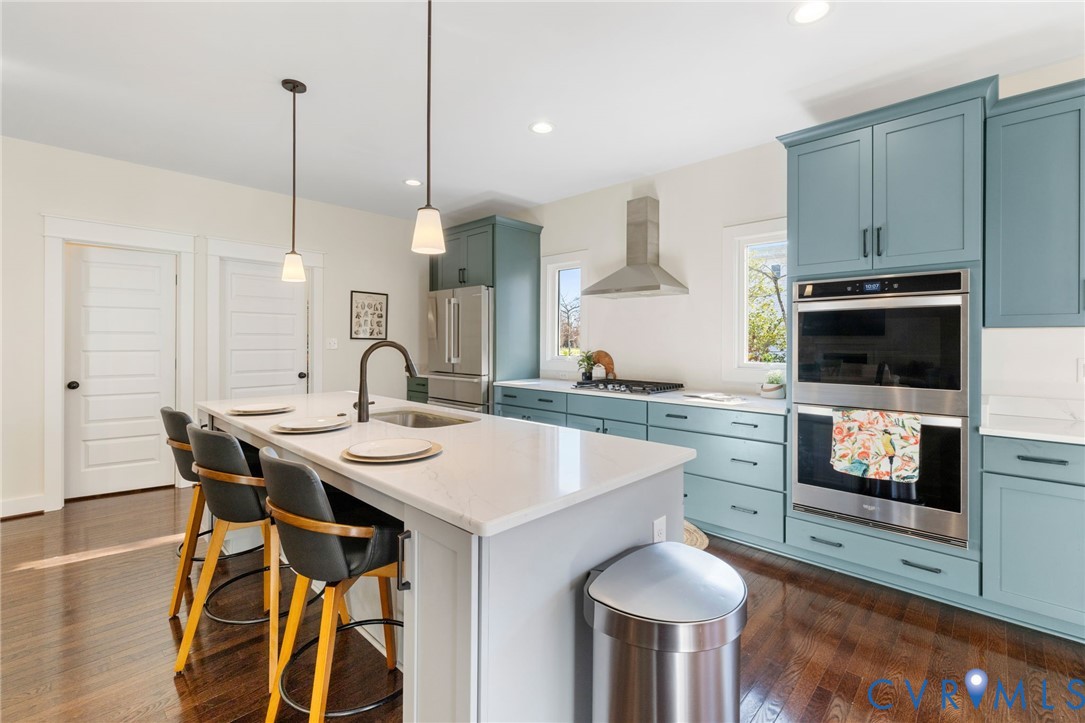 9461 Wickham Crossing Way Ashland, VA 23005 - Photo 5 of 30 a kitchen with stainless steel appliances a kitchen island a stove a table and chairs in it