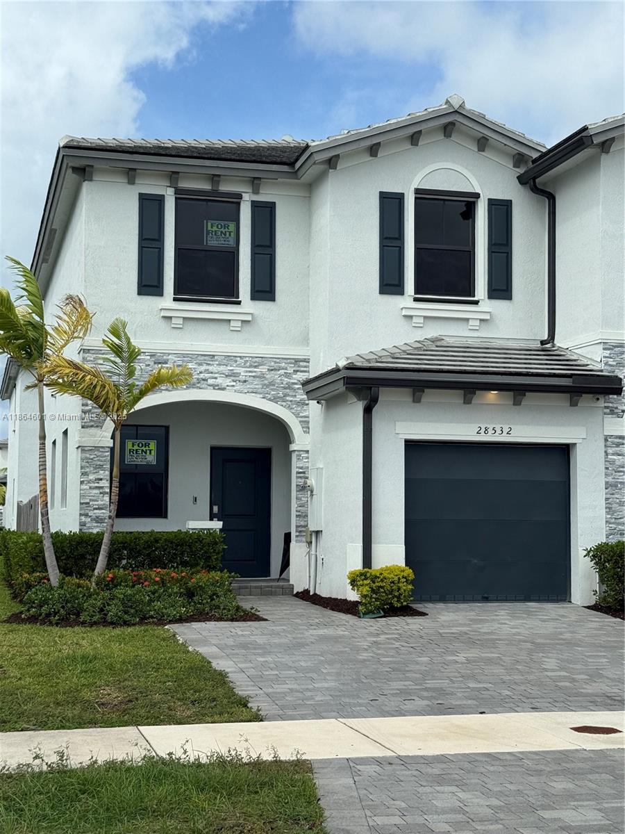 28532 Southwest 133rd Path Homestead, FL 33033 - Photo 2 of 18 a front view of a house with a yard and garage