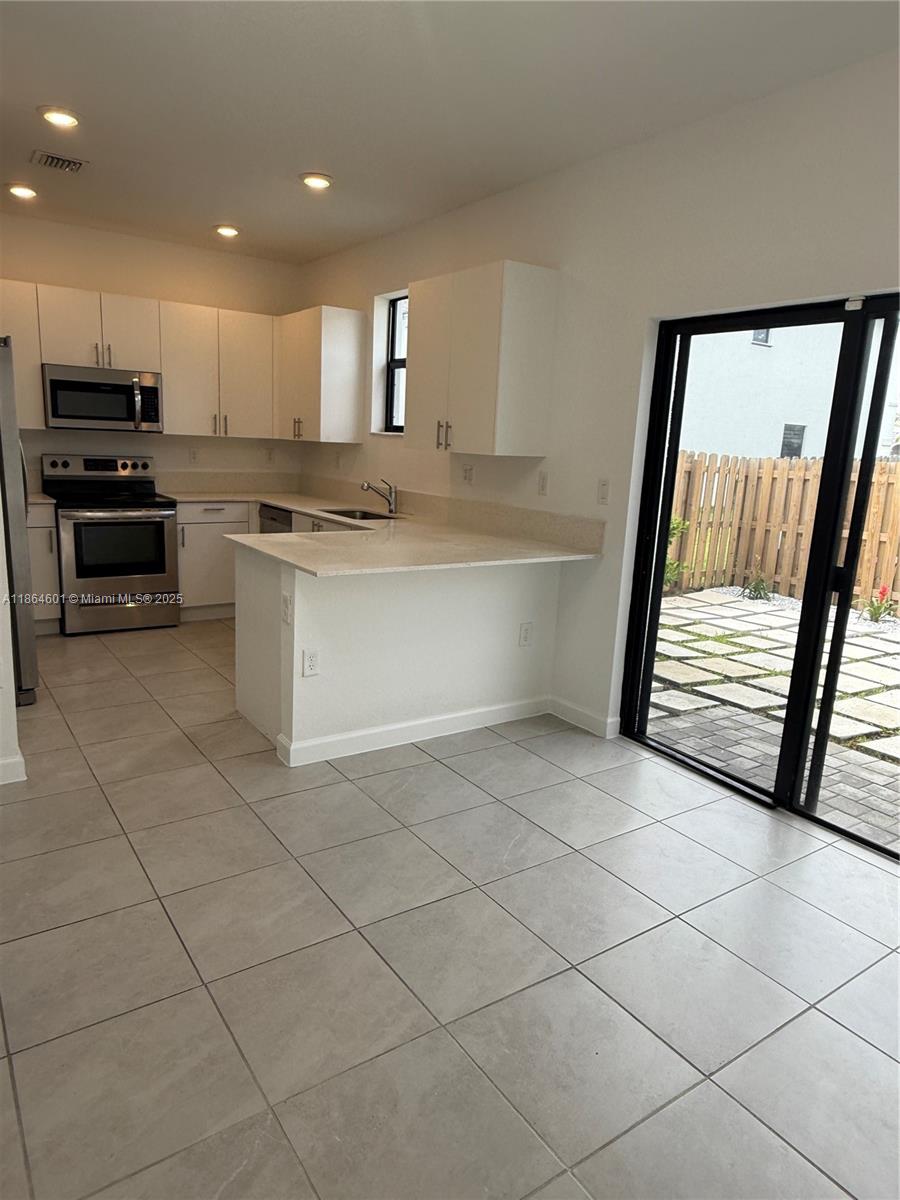 28532 Southwest 133rd Path Homestead, FL 33033 - Photo 7 of 18 a kitchen with granite countertop a stove a sink and a refrigerator