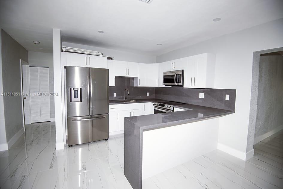 516 Southwest 66th Avenue Miami, FL 33144 - Photo 5 of 27 a kitchen with stainless steel appliances a refrigerator a stove a microwave and a refrigerator