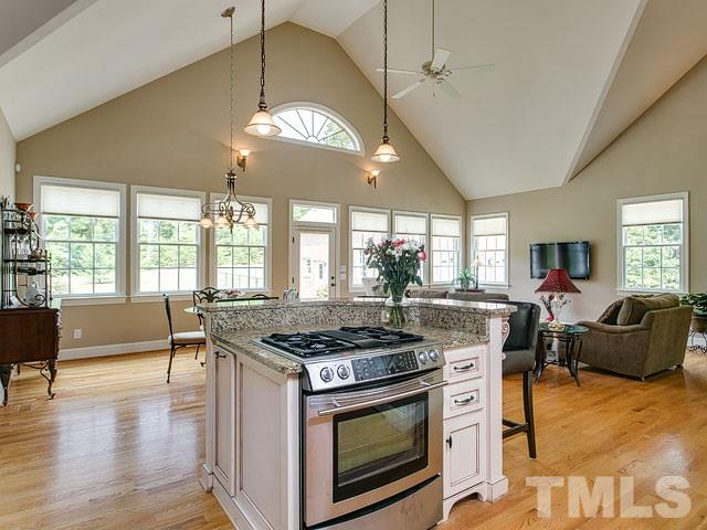 1378 Bowen Road Rougemont, NC 27572 - Photo 13 of 25 a kitchen with stainless steel appliances granite countertop a stove a sink dishwasher a dining table and chairs with wooden floor