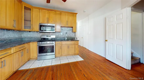 a kitchen with stainless steel appliances granite countertop a stove a sink and a microwave