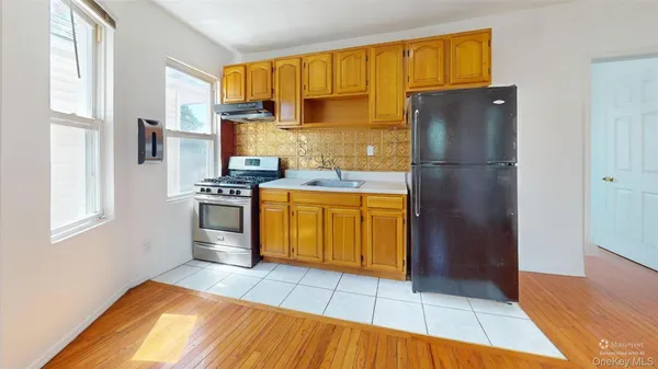 a kitchen with a refrigerator a stove and wooden cabinets