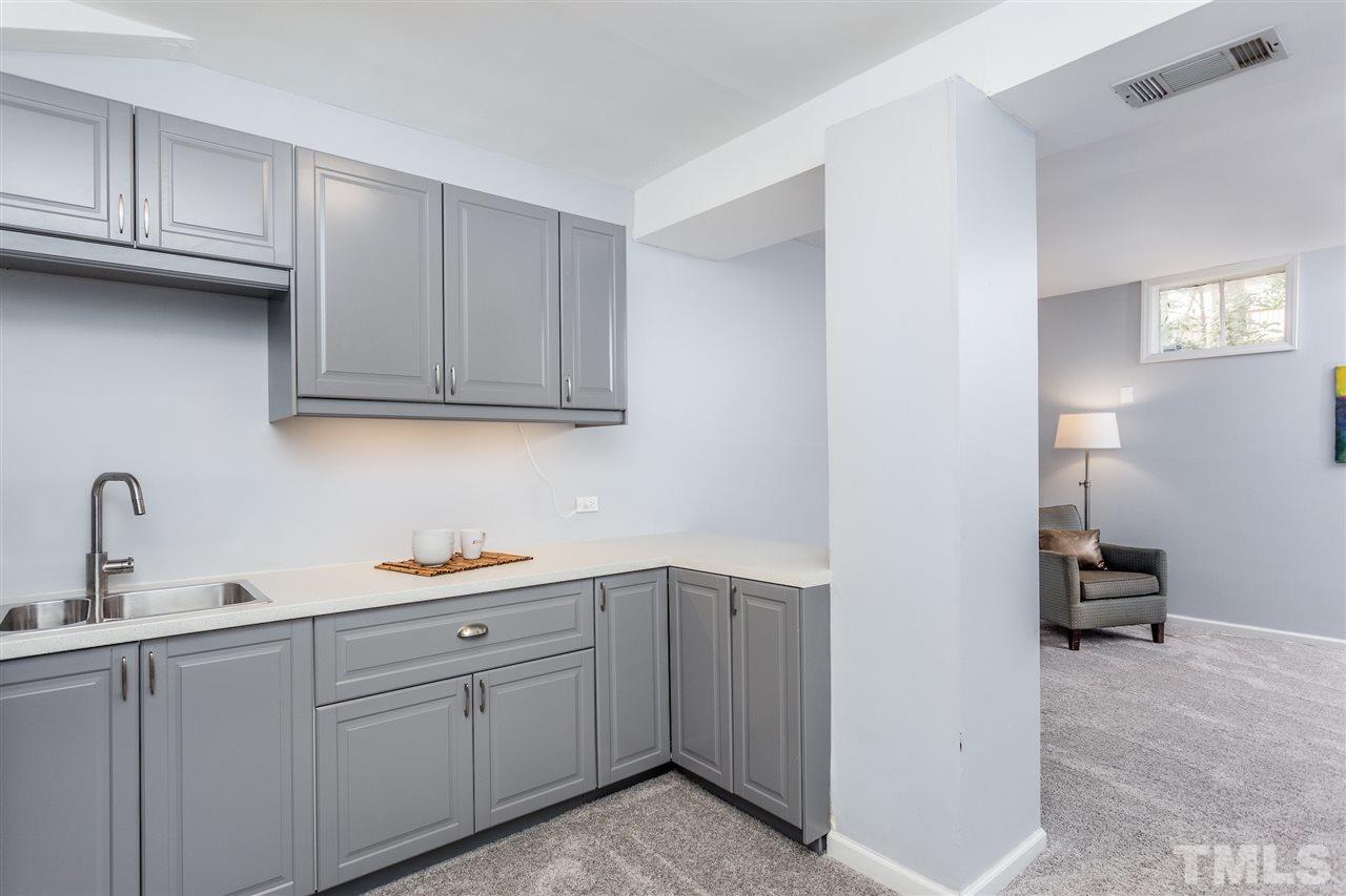 2612 Barmettler Street Raleigh, NC 27607 - Photo 18 of 24 a kitchen with white cabinets and a sink