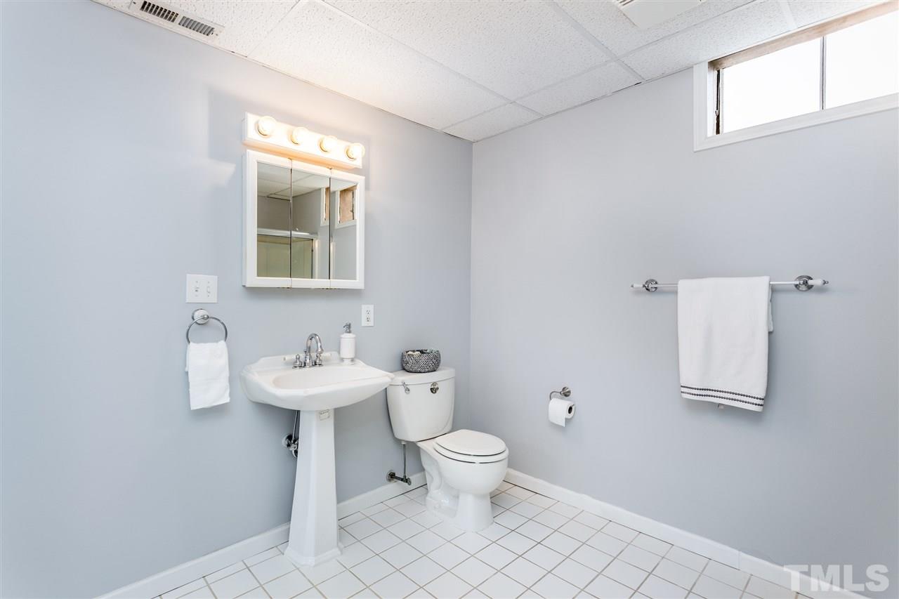 2612 Barmettler Street Raleigh, NC 27607 - Photo 20 of 24 a bathroom with a toilet a sink and a mirror