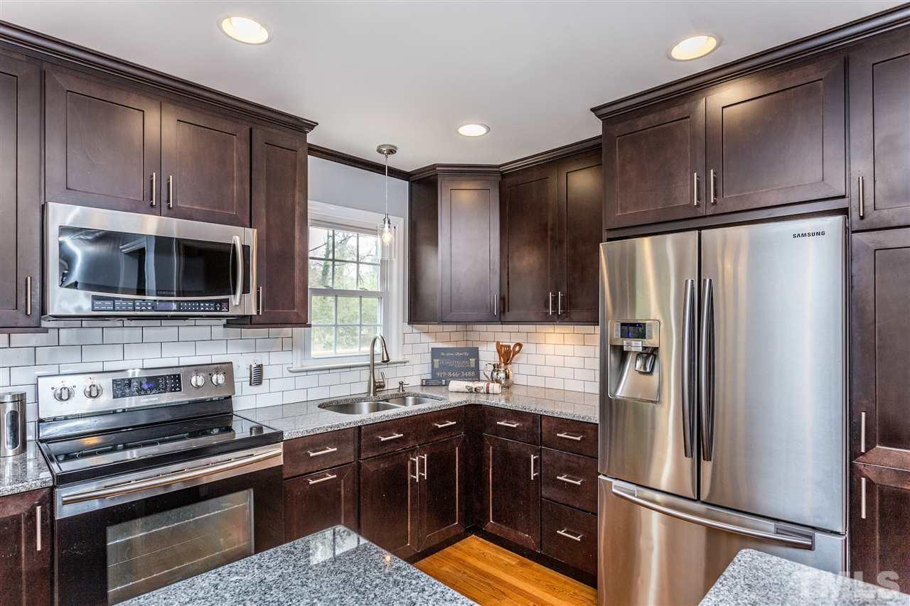 2612 Barmettler Street Raleigh, NC 27607 - Photo 7 of 24 a kitchen with stainless steel appliances granite countertop a refrigerator stove and sink