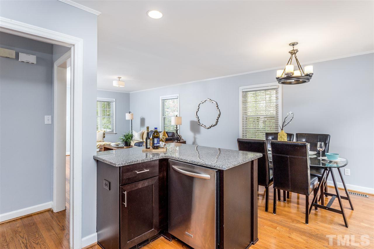 2612 Barmettler Street Raleigh, NC 27607 - Photo 10 of 24 a view of a dining room with furniture a chandelier and wooden floor