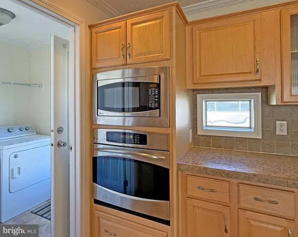 a kitchen with granite countertop cabinets stainless steel appliances and a window