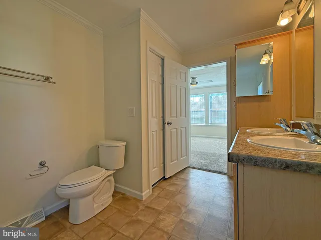 a bathroom with a granite countertop sink a toilet and a mirror