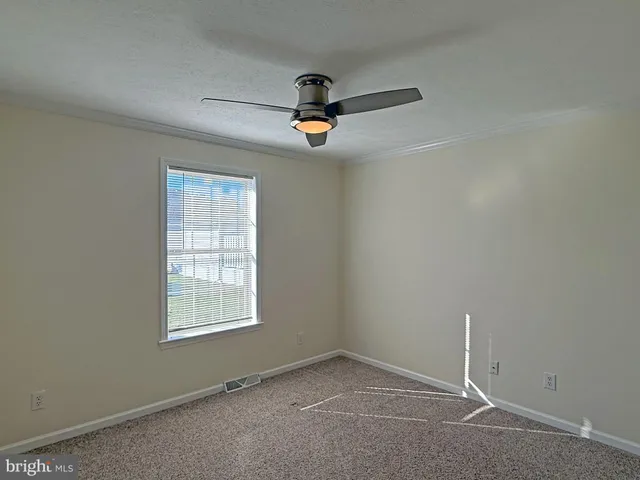 an empty room with a ceiling fan and a window