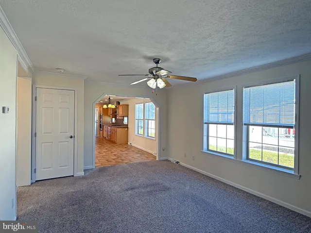 a view of a livingroom with a ceiling fan and window