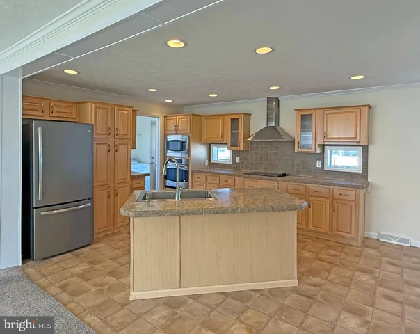 a kitchen with stainless steel appliances granite countertop a refrigerator a sink and a stove