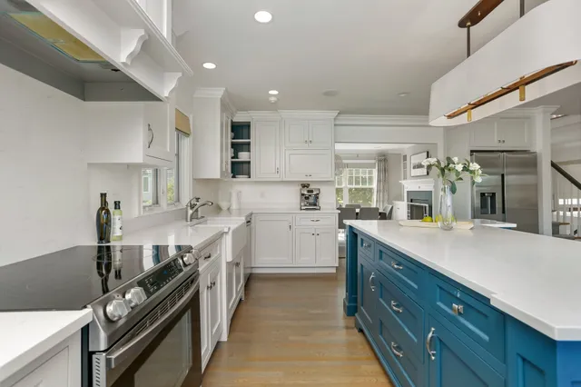 a large kitchen with kitchen island a sink stainless steel appliances and cabinets