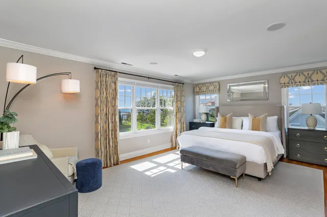 a bed sitting in a spacious bedroom next to a window