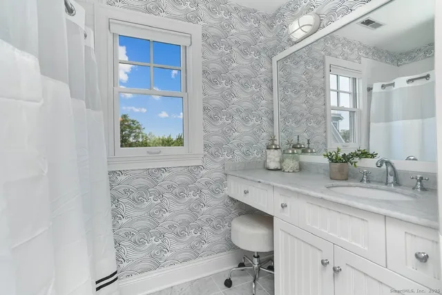 a bathroom with a sink a toilet and a mirror