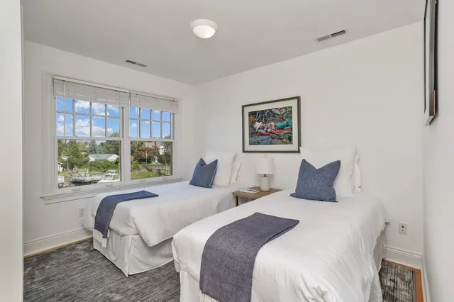 a bedroom with two beds and a large window