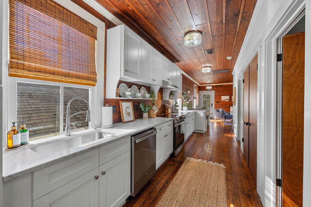 4117 Avenue R Galveston, TX 77550 - Photo 12 of 39 a kitchen with stainless steel appliances granite countertop lots of counter top space and wooden floor