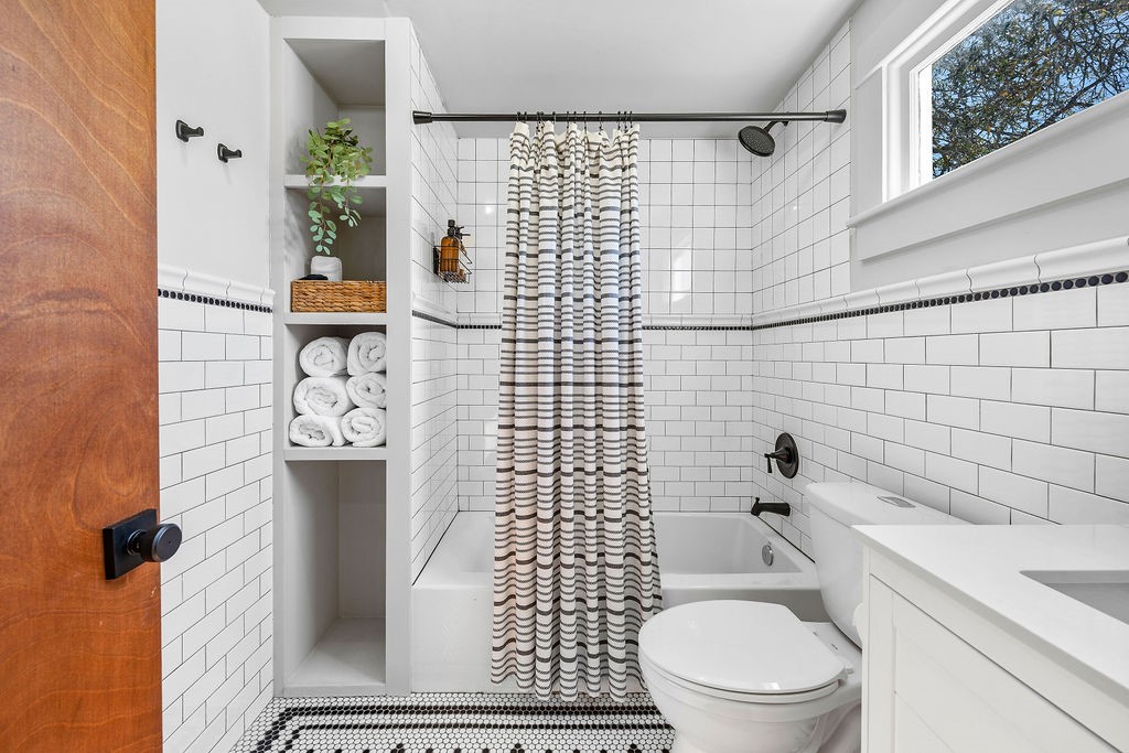 4117 Avenue R Galveston, TX 77550 - Photo 23 of 39 a bathroom with a toilet and a shower curtain
