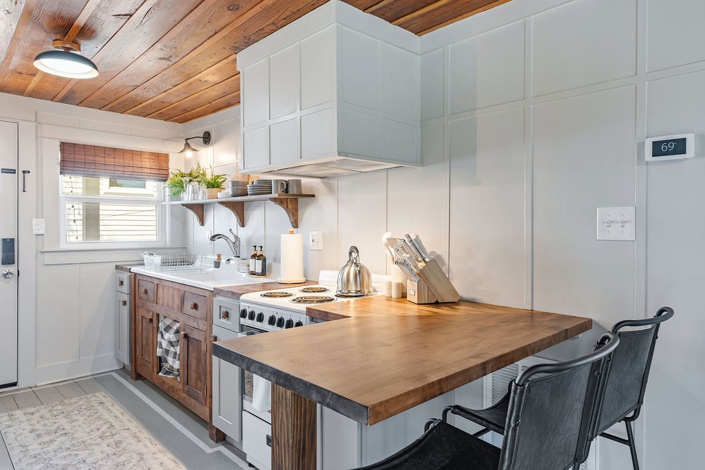 4117 Avenue R Galveston, TX 77550 - Photo 31 of 39 a kitchen with a table chairs and wooden cabinets