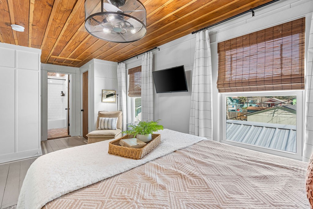 4117 Avenue R Galveston, TX 77550 - Photo 36 of 39 a bedroom with a bed a flat screen tv and a large window with the outer view