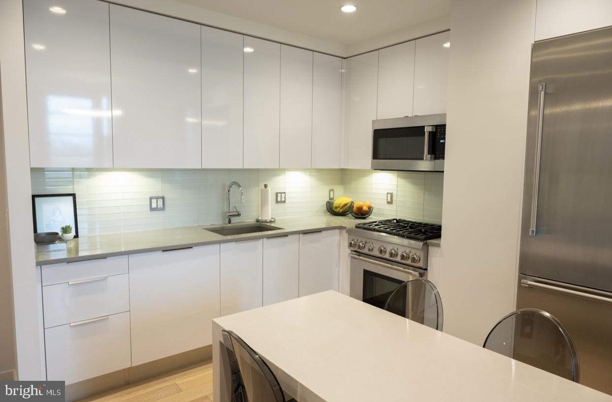 45 Sutton Square Southwest, Unit 1115 Washington, DC 20024 - Photo 6 of 14 a kitchen with a sink a refrigerator and cabinets