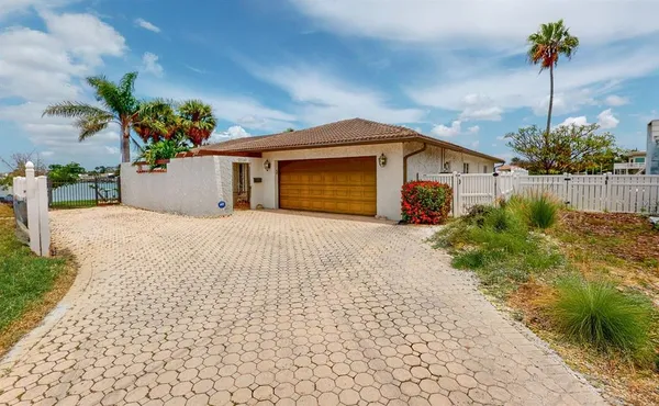 a front view of a house with a yard and potted plants