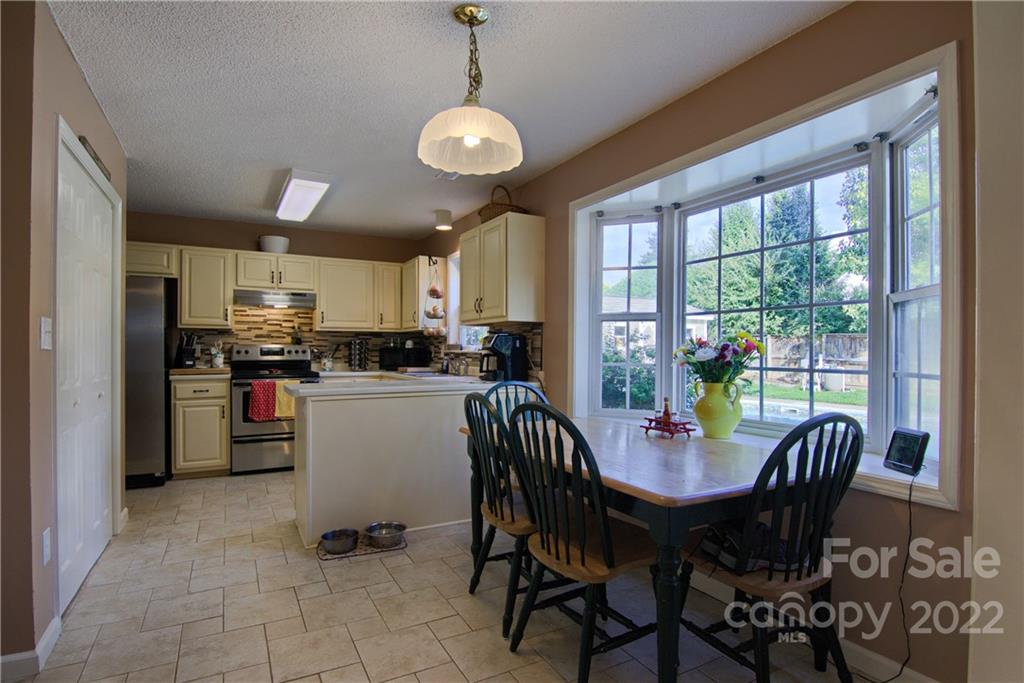 86 Rolling Meadow Road Fletcher, NC 28732 - Photo 10 of 36 a view of a dining room and livingroom with furniture a rug a kitchen view and large windows