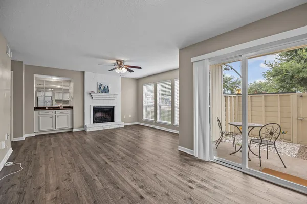 a view of a big room with wooden floor kitchen view and windows