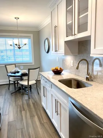 a kitchen with a sink cabinets and wooden floor