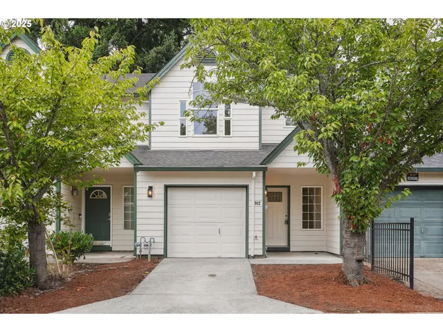 a front view of a house with a garden and yard
