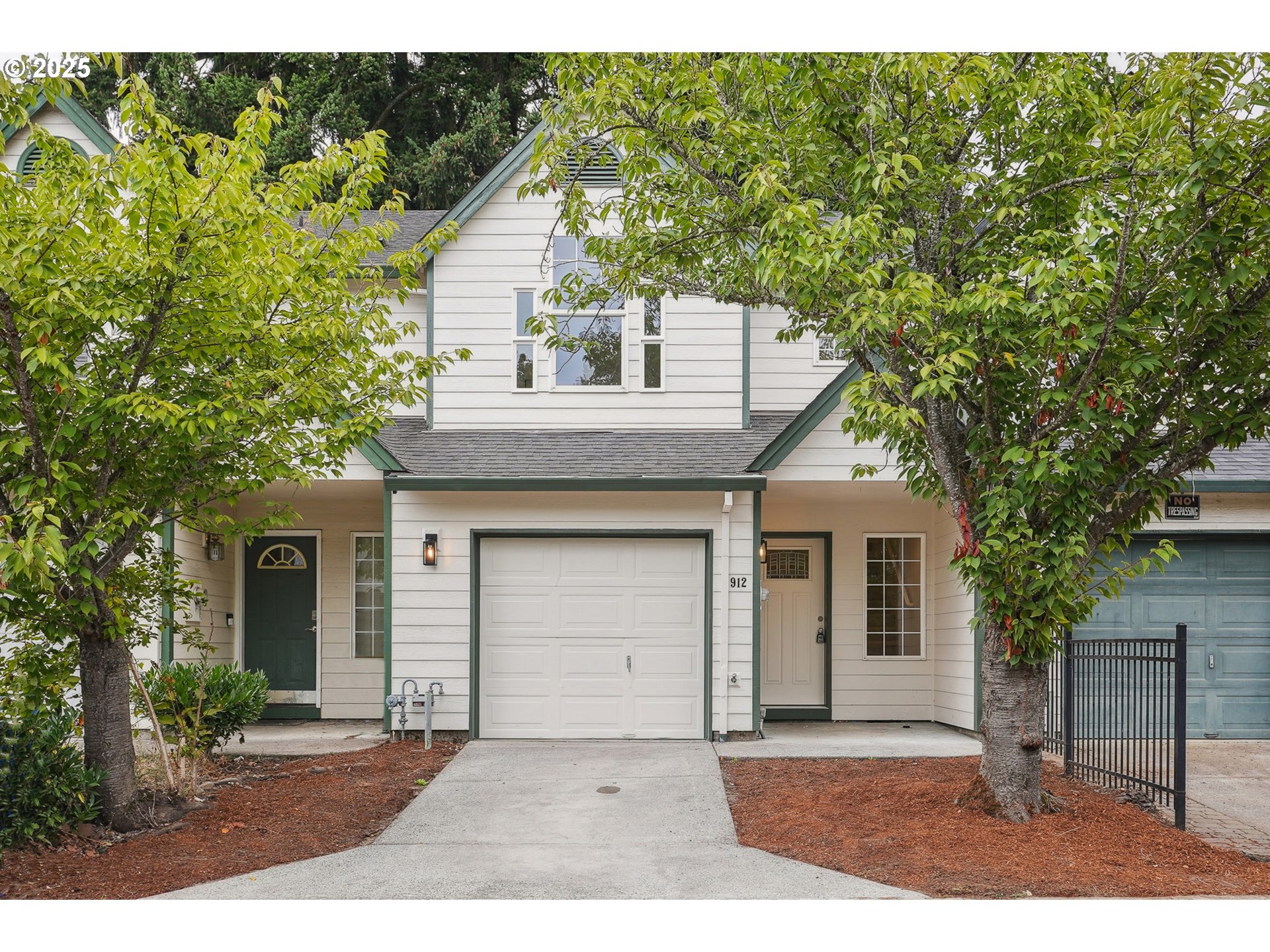 a front view of a house with a garden and yard