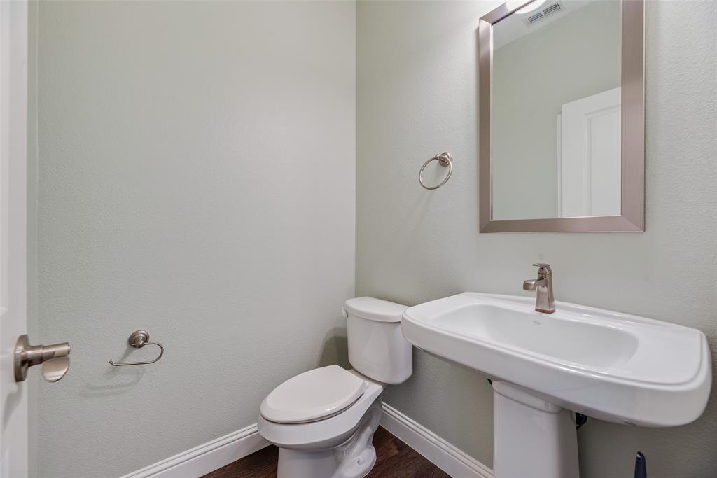 4670 I Rhett Lane, Unit I Carrollton, TX 75010 - Photo 30 of 31 Pedestal sink with a single-handle faucet, rectangular framed mirror, and wood-finish flooring