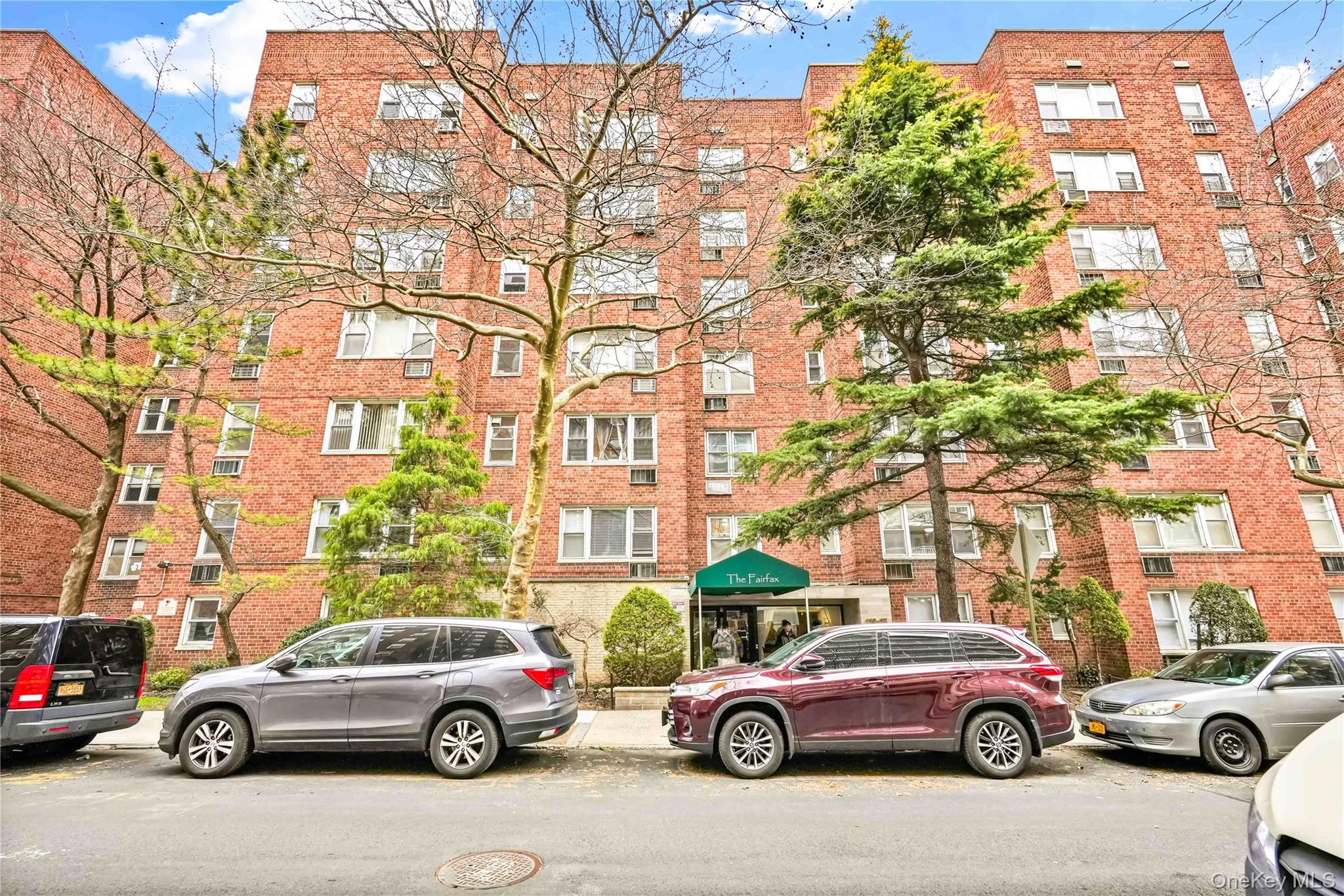 a front view of a residential apartment building with a parked car