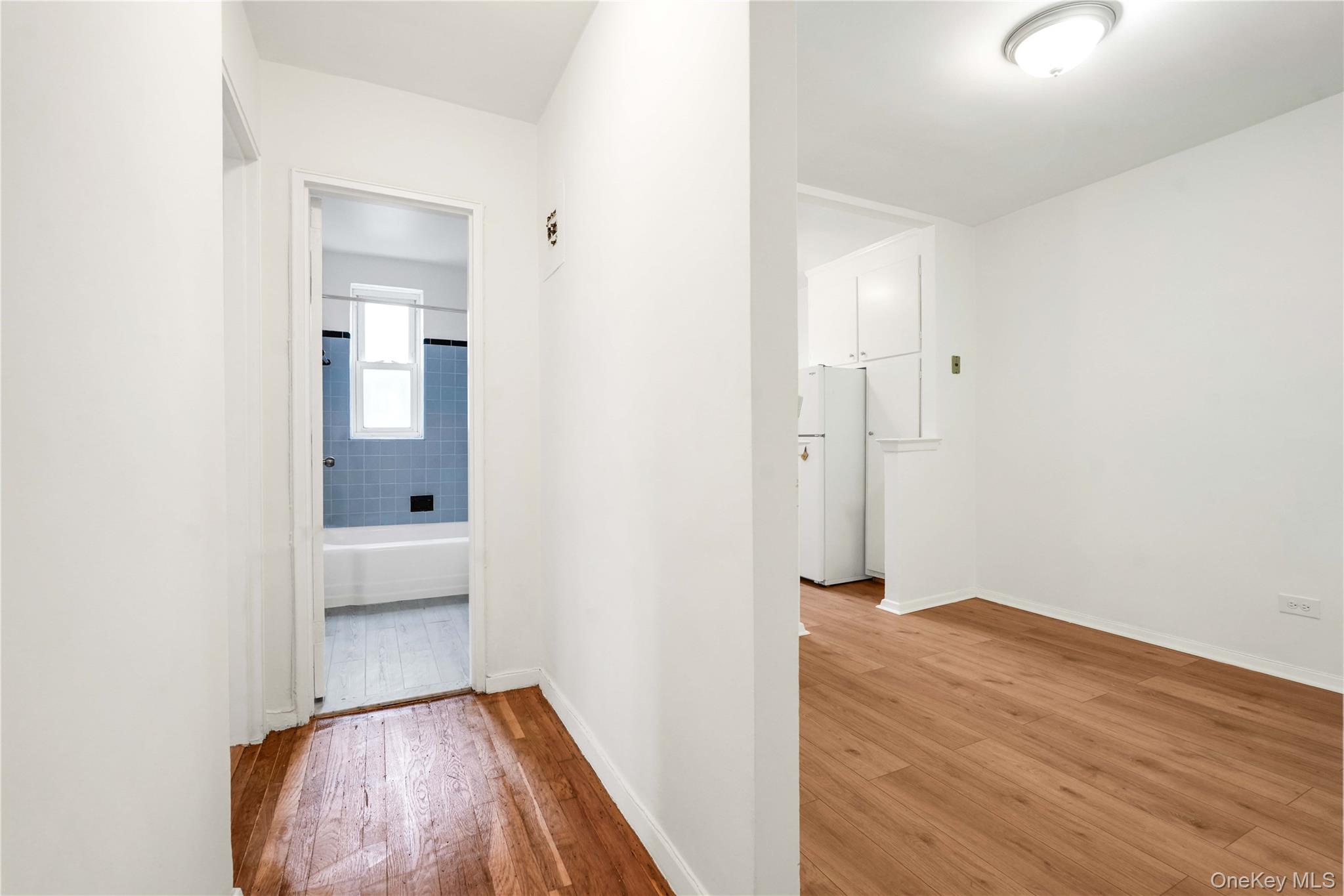 110-15 71st Road, Unit 6J Queens, NY 11375 - Photo 12 of 23 an empty room with wooden floor and bathroom